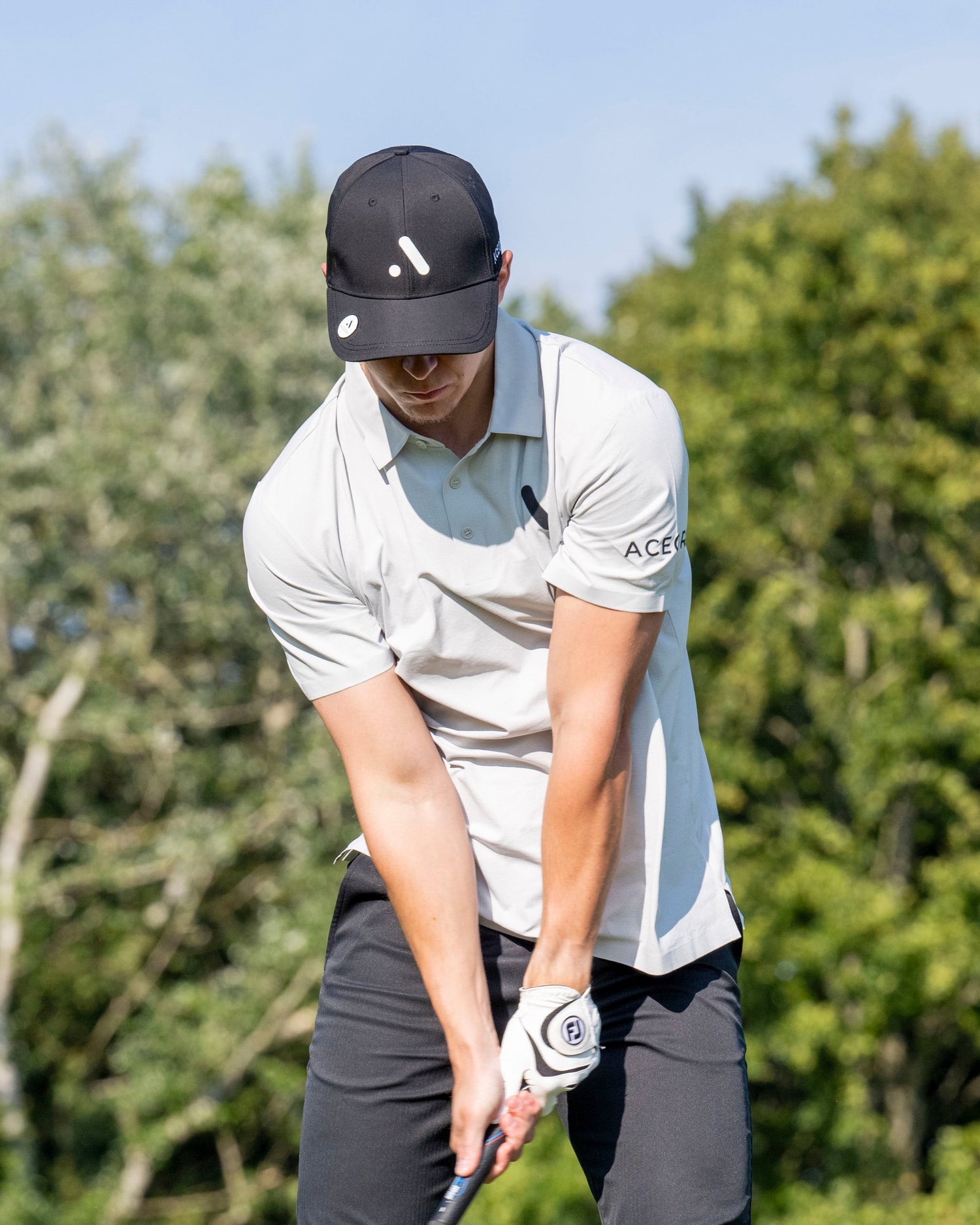 Person playing golf with trees in the background