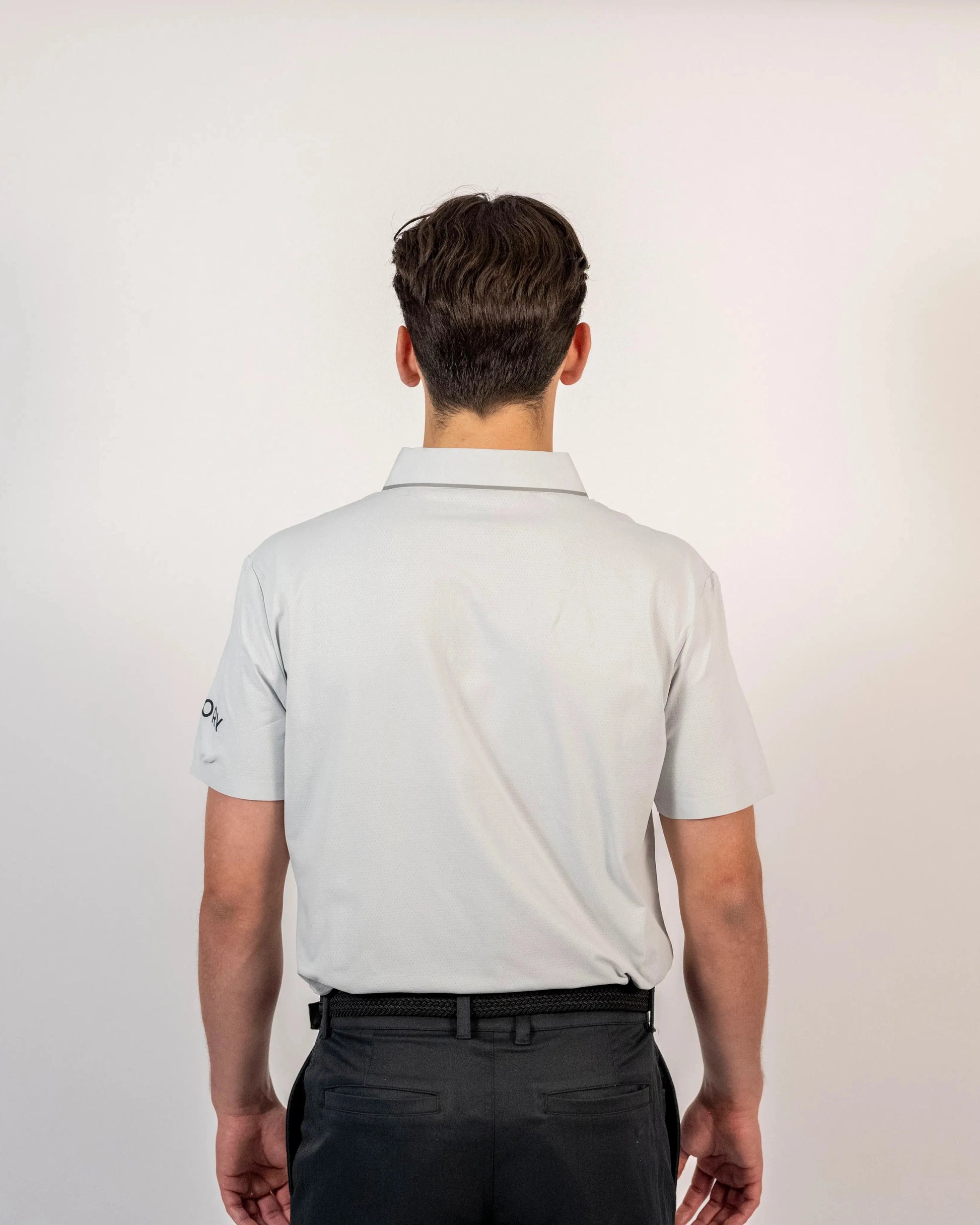 Back view of a model wearing the light grey Aceory Essentials polo showing the minimalist fit and collar.