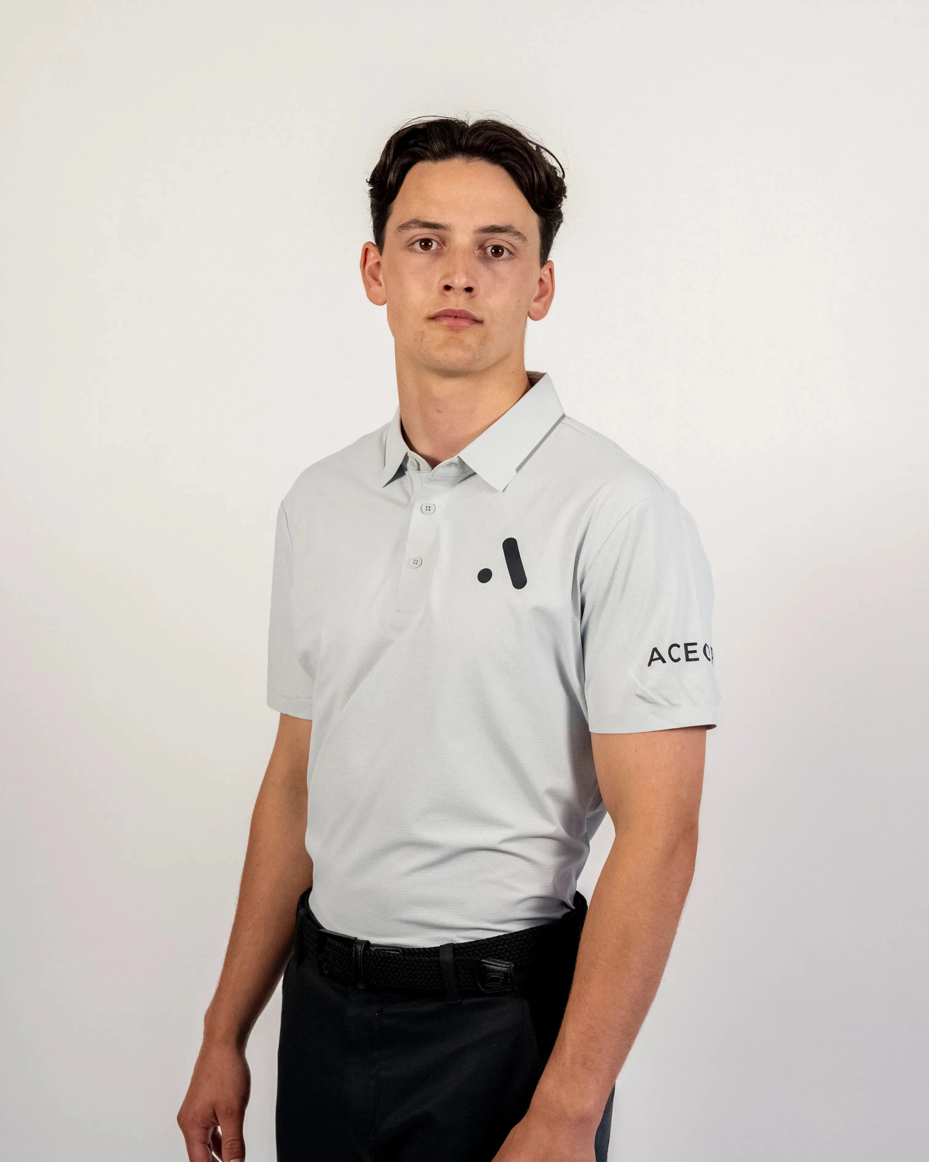 Front view of a model wearing the light grey Aceory Essentials polo in studio lighting.