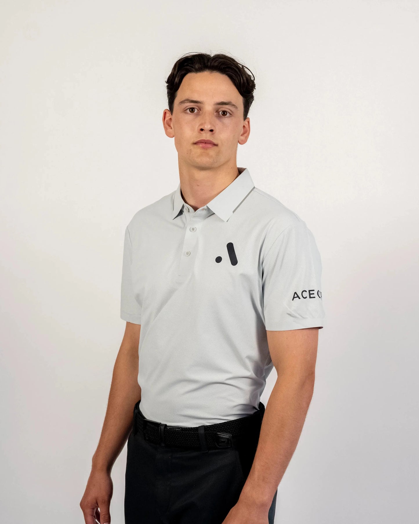 Front view of a model wearing the light grey Aceory Essentials polo in studio lighting.