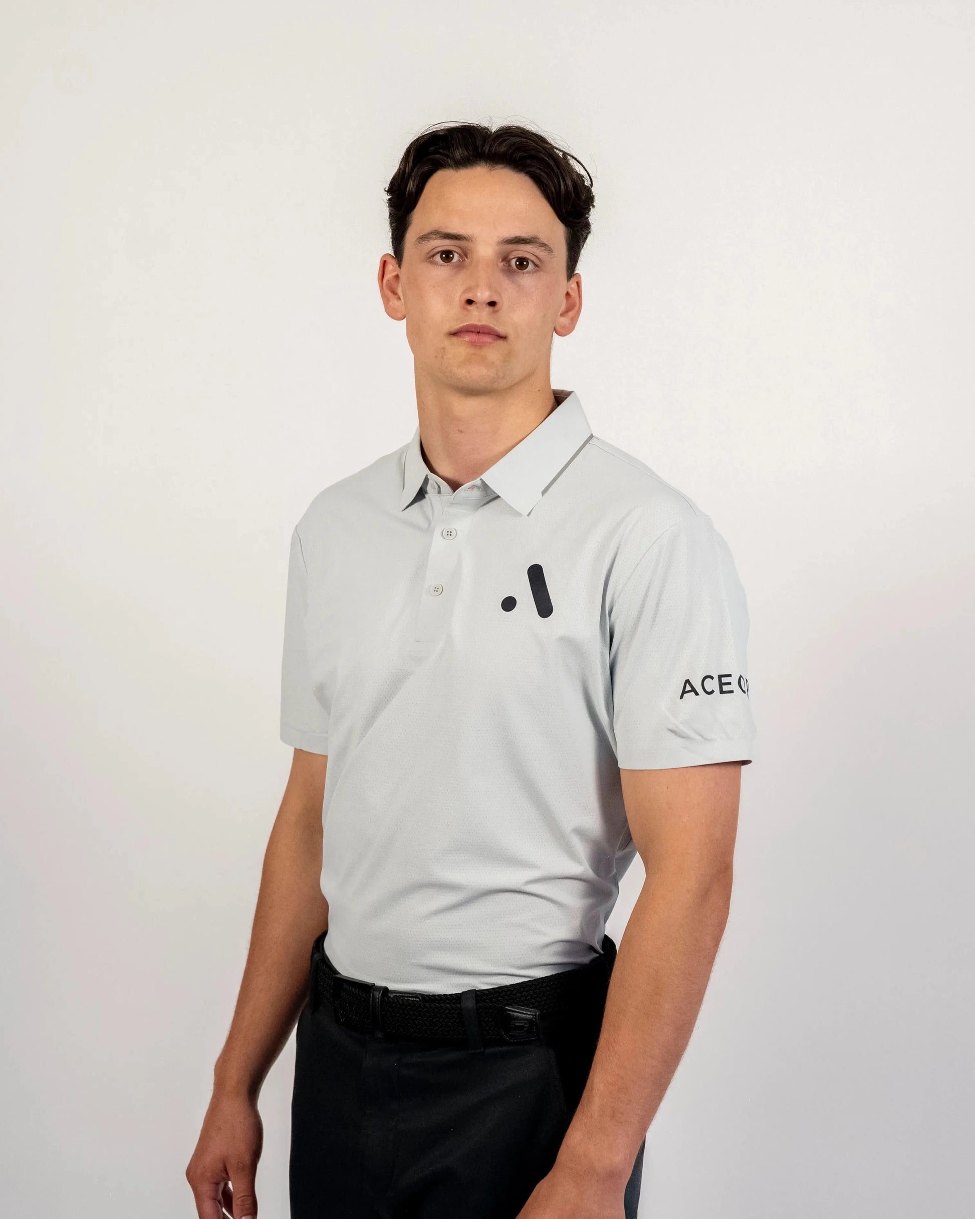 Front view of a model wearing the light grey Aceory Essentials polo in studio lighting.