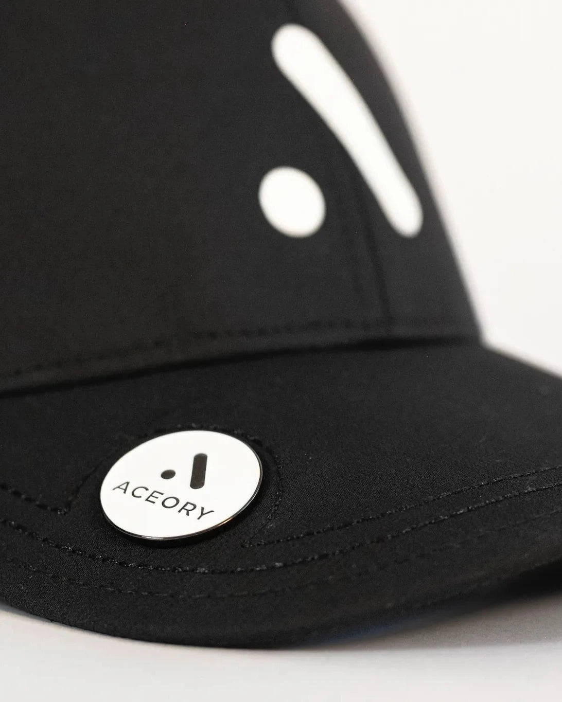 Detailed close-up of the Aceory magnetic marker attached to the cap brim.