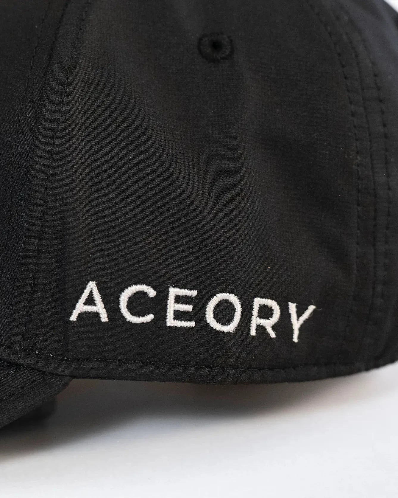 Side close-up of the Aceory golf cap showing embroidered brand name.