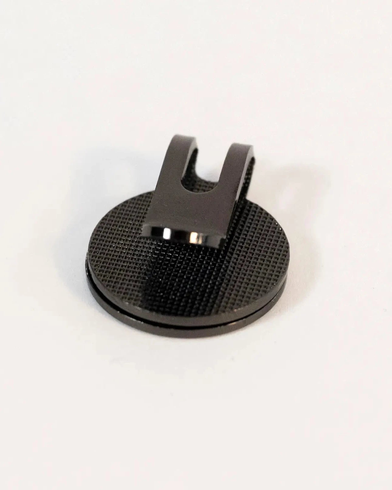 Back view of the magnetic cap clip showing the textured surface and metal clip.
